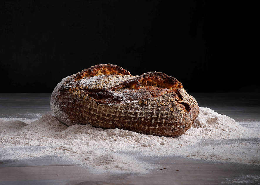 Dinkel Plus Brot auf Holztisch mit Mehl