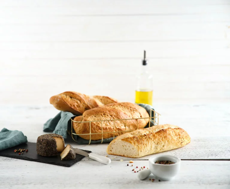 Auswahl an Baguettes im Korb mit Käse und Pfeffer